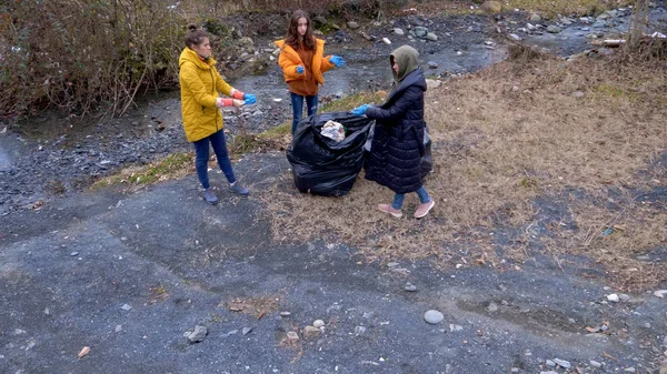 Masalah lingkungan. relawan mengumpulkan sampah di tepi sungai — Stok Foto