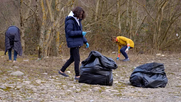 Περιβαλλοντικά προβλήματα. εθελοντές συλλέγουν σκουπίδια στις όχθες του ποταμού — Φωτογραφία Αρχείου