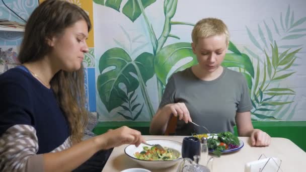 Dos mujeres comiendo en restaurantes vegetarianos comida saludable — Vídeos de Stock