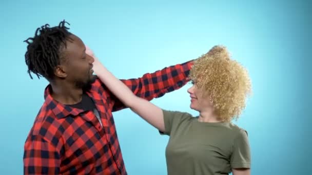 Uomo africano e donna caucasica con acconciatura afro. sfondo blu — Video Stock