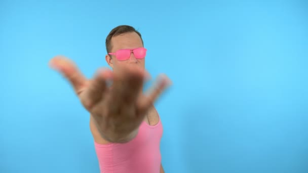Сумасшедший в розовых очках приходит сюда жестом на голубом фоне — стоковое видео