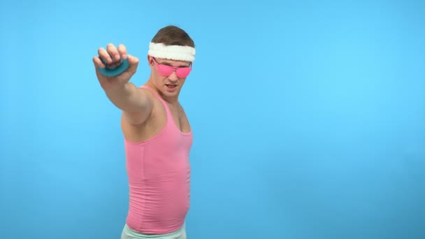 Ein verspielter gutaussehender Mann hält einen manuellen Expander in der Hand. helle Fitness. — Stockvideo