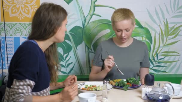 İki kadın vejetaryen restoranlarında sağlıklı yiyecekler yiyor. — Stok video