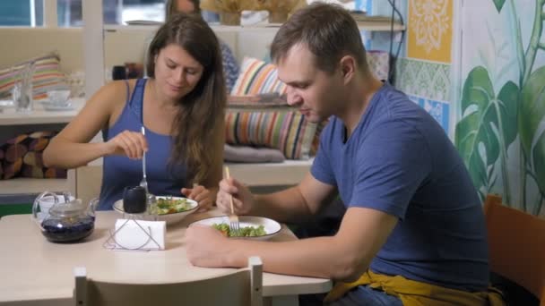 Casal homem e mulher comendo em restaurantes vegetarianos comida saudável — Vídeo de Stock