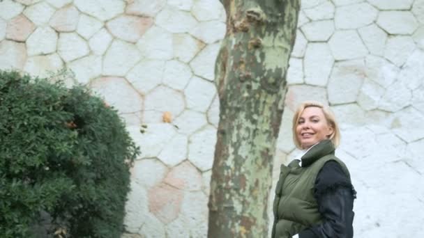 Mooie stijlvolle trendy blonde vrouw wandelen in een stad Park in de herfst — Stockvideo