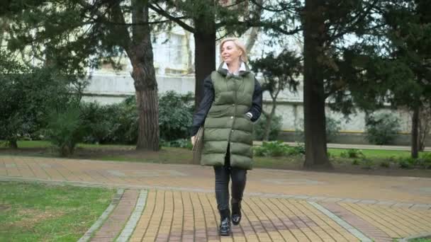 Mooie stijlvolle trendy blonde vrouw wandelen in een stad Park in de herfst — Stockvideo