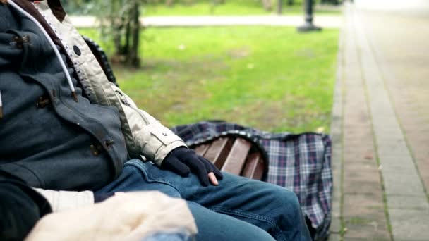 Evsiz bir çift, bir adam ve bir kadın şehir parkında bankta oturuyor. — Stok video
