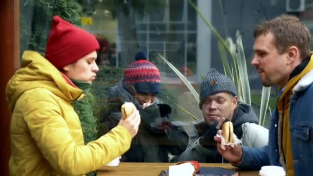 Ein paar obdachlose Männer und Frauen bitten Besucher eines Straßencafés um Essen — Stockvideo