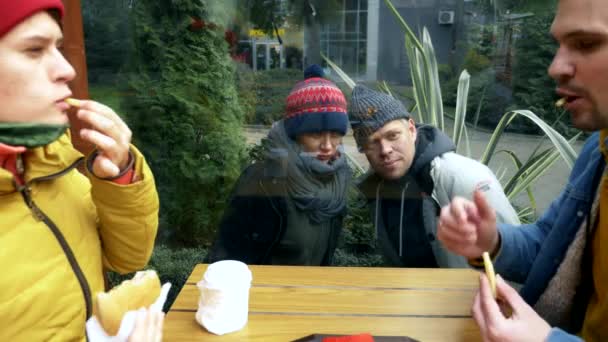 Un par de hombres y mujeres sin hogar piden comida a los visitantes de un café callejero — Vídeo de stock