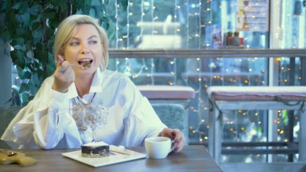 Schöne elegante elegante blonde Frau, die sich in einem Café ausruht — Stockvideo