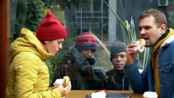 ホームレスの男性や女性の何人かは観光客からストリートカフェまで食べ物を求めています — ストック動画