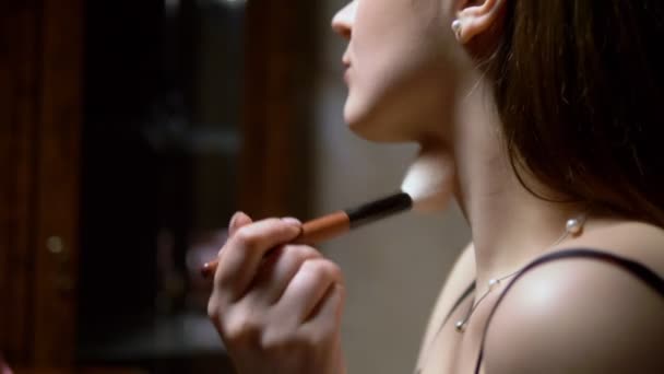 Красивая молодая девушка наносит порошок на лицо кистью — стоковое видео
