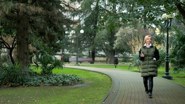 Beautiful stylish trendy blond woman walking in a city Park in autumn — 스톡 사진