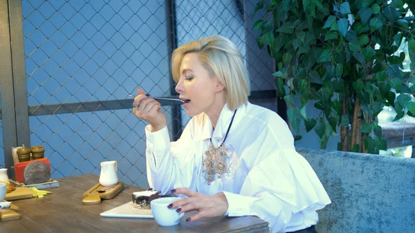 Vacker elegant elegant blond kvinna vilar i ett café — Stockfoto