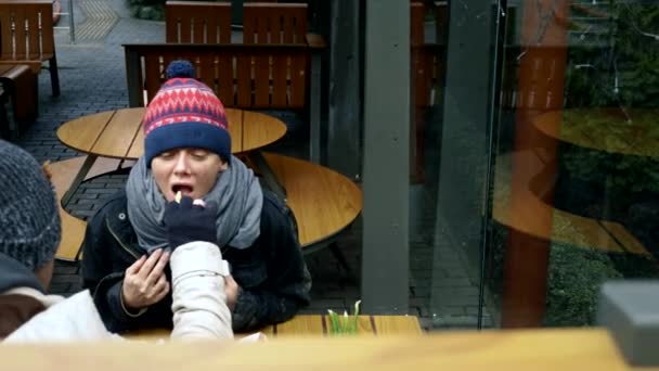 Couple de sans-abri, homme et femme mangeant les restes d'une table dans un café de rue — Video