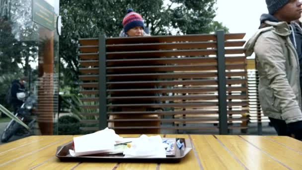 Couple de sans-abri, homme et femme mangeant les restes d'une table dans un café de rue — Video