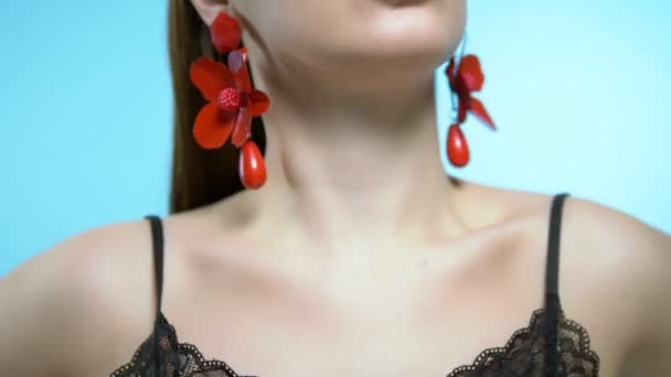 Portrait of a beautiful girl. blue background. the girl wears earrings — Stock Video