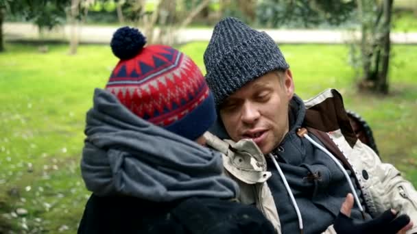 Una pareja sin hogar, un hombre y una mujer en un banco en un parque de la ciudad — Vídeo de stock