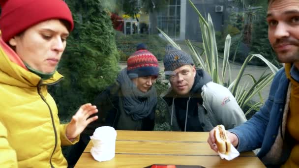 Un par de hombres y mujeres sin hogar piden comida a los visitantes de un café callejero — Vídeo de stock