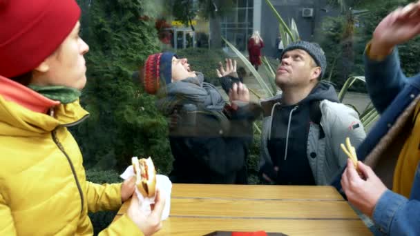 Un couple d'hommes et de femmes sans abri demandent de la nourriture aux visiteurs d'un café de rue — Video