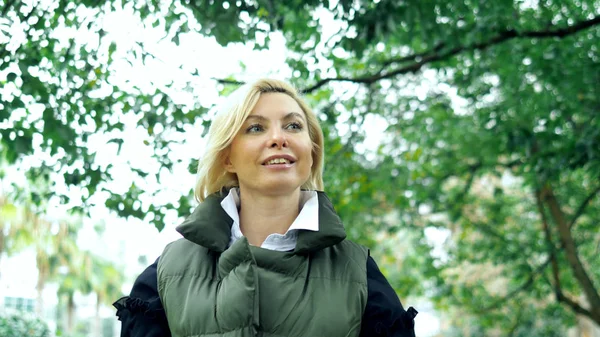 Schöne stylische trendige blonde Frau zu Fuß in einem Stadtpark im Herbst — Stockfoto