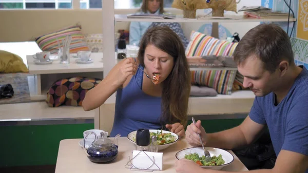 Casal homem e mulher comendo em restaurantes vegetarianos comida saudável — Fotografia de Stock