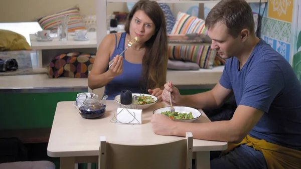 Casal homem e mulher comendo em restaurantes vegetarianos comida saudável — Fotografia de Stock