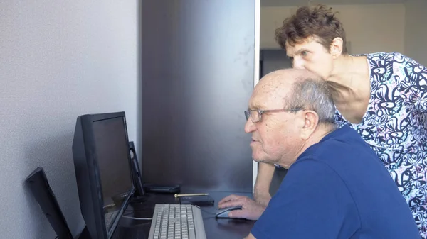 Літня пара чоловік і жінка, використовуючи комп'ютер разом — стокове фото