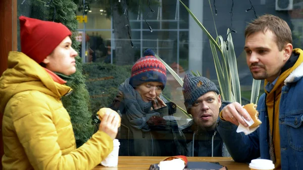 Un par de hombres y mujeres sin hogar piden comida a los visitantes de un café callejero —  Fotos de Stock