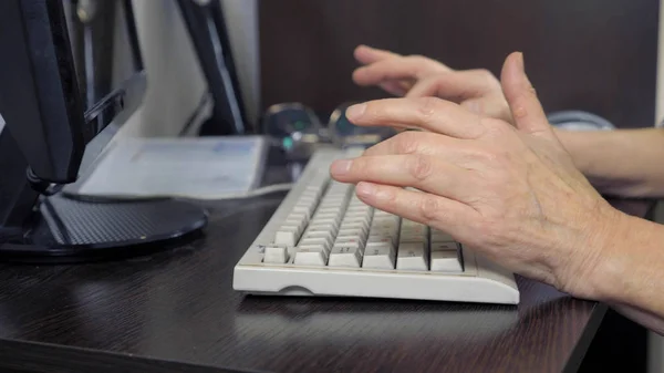 Primer plano de las manos de una anciana escribiendo en un teclado — Foto de Stock