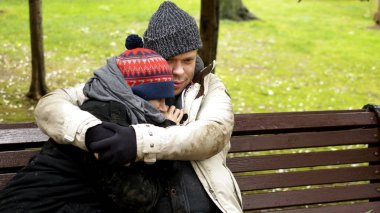 Evsiz bir çift, bir adam ve bir kadın şehir parkında bankta oturuyor.