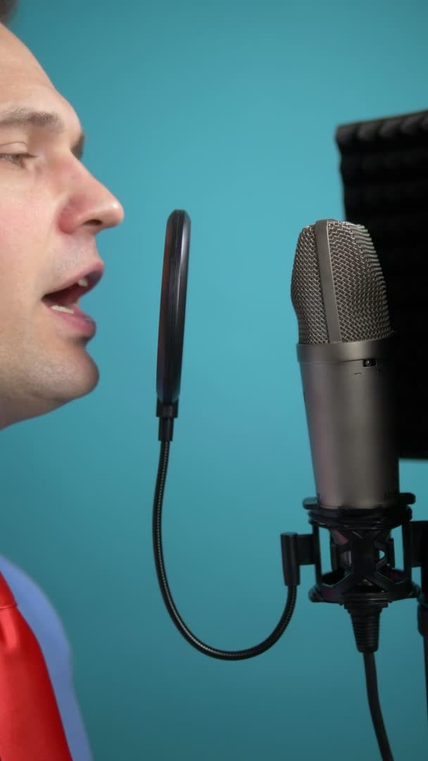 Una imagen vertical. joven hombre guapo en una corbata cantando en un micrófono . — Vídeo de stock