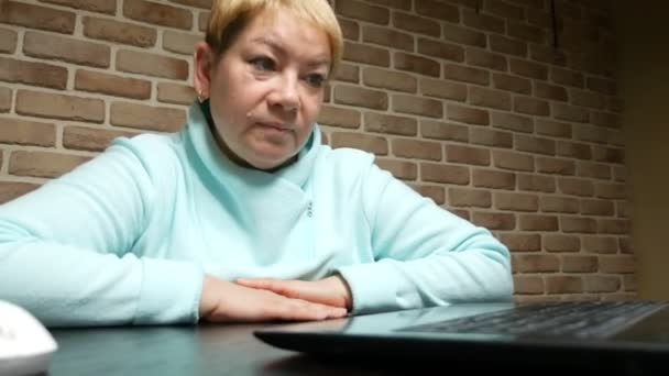 一位老年妇女用笔记本电脑通过视频会议交谈 — 图库视频影像