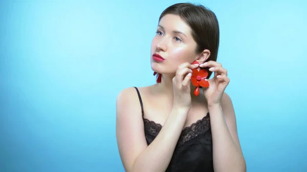 Portrait d'une belle fille. fond bleu. la fille porte des boucles d'oreilles — Photo