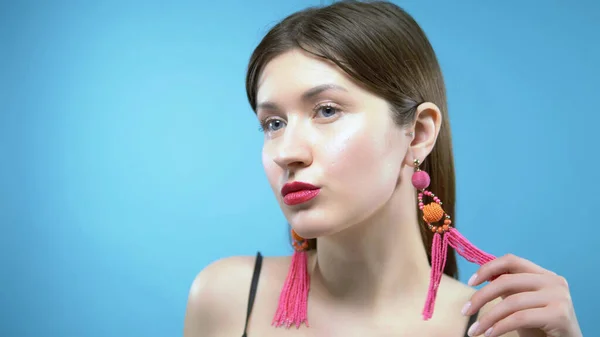 Portrait of a beautiful girl. blue background. the girl wears earrings — Stock Photo, Image