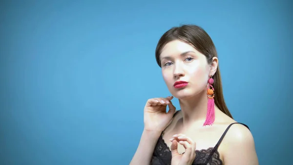 Portrait of a beautiful girl. blue background. the girl wears earrings — 스톡 사진