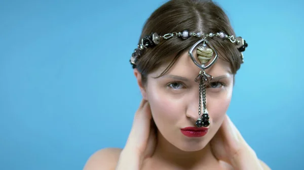 The girl wears a head black agate beads with a pendant in the shape of a heart — Stock Photo, Image