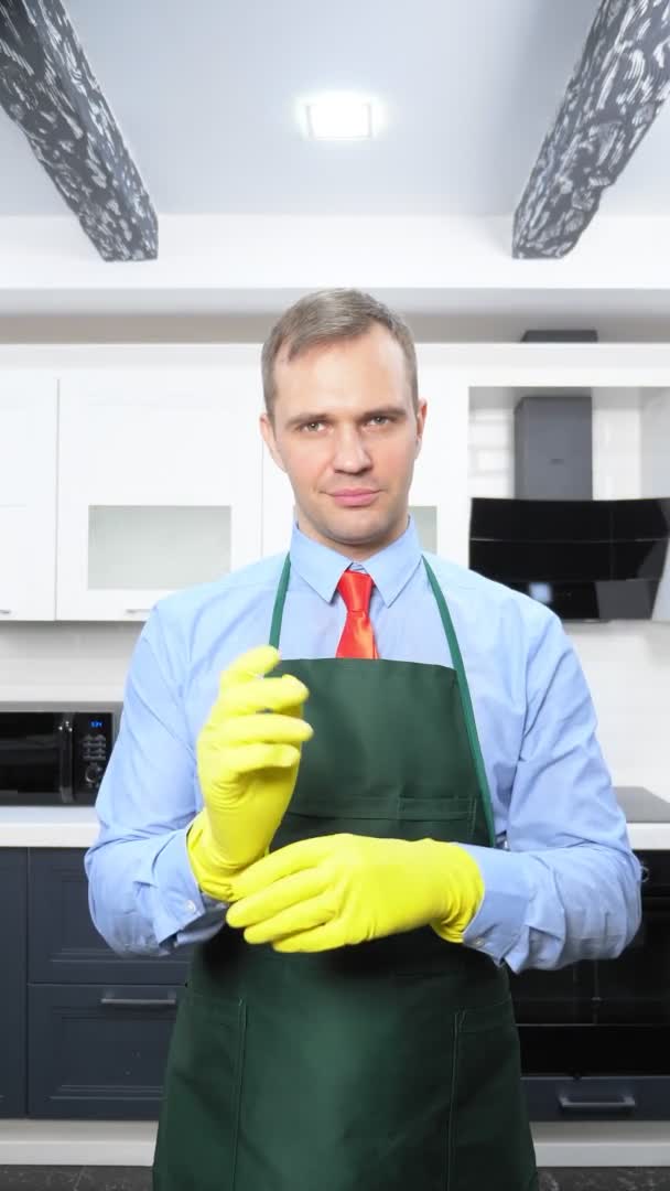 Una imagen vertical. hombre guapo en corbata y delantal con guantes de goma — Vídeo de stock