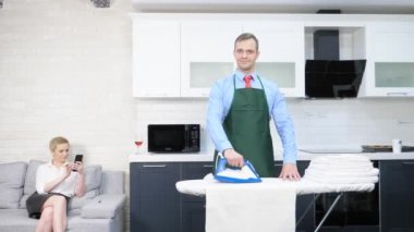 Yakışıklı adam iç çamaşırı okşuyor, kadın kanepede dinleniyor.