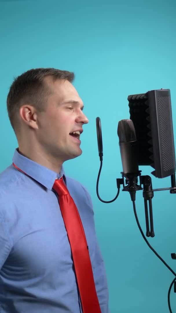 Вертикальное изображение. человек поет в микрофон в студии звукозаписи — стоковое видео