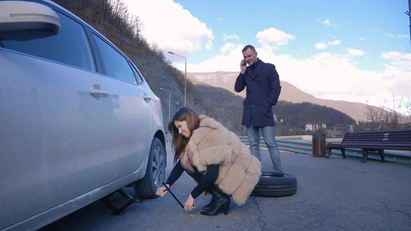 Humor. Een vrouw die een auto verwisselt. man aan de telefoon — Stockfoto