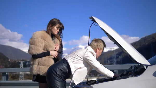 Twee meisjes zijn het opladen van de batterij in een auto staan aan de kant van de weg — Stockfoto