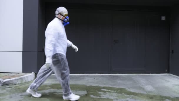 As pessoas passam por edifícios tecnológicos em trajes de proteção e respiradores — Vídeo de Stock