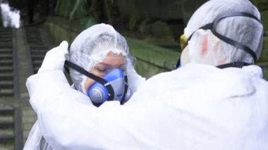 Koruyucu giysili insanlar solunum cihazlarını çıkarıp boğulmaya başlıyorlar.