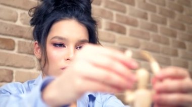 Güzel esmer kız ahşap bir mankenle eskiz çiziyor.