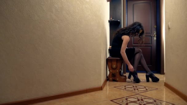 En trött kvinna återvänder hem och tar av sig skorna. Livsstil — Stockvideo
