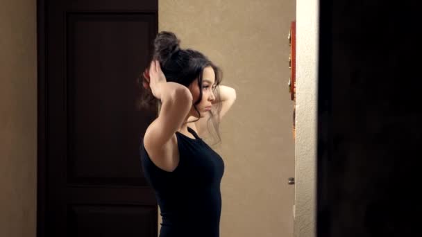 Κορίτσι κάνει τον εαυτό της μια τρίχα στέκεται μπροστά από έναν καθρέφτη στο σπίτι — Αρχείο Βίντεο