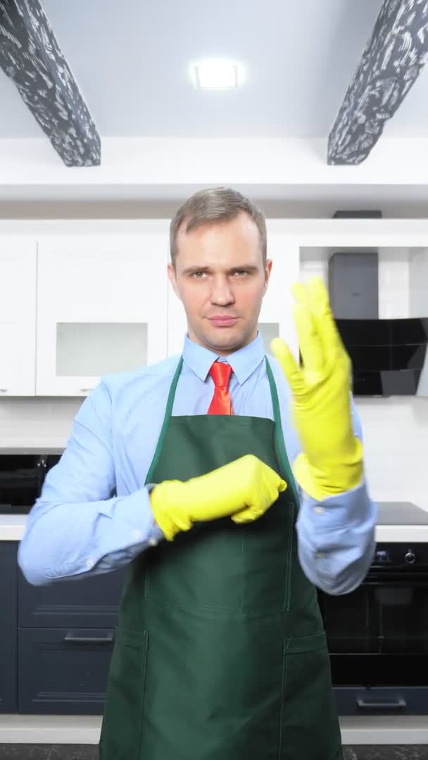 Ein vertikales Bild. schöner Mann in Krawatte und Schürze mit Gummihandschuhen — Stockvideo