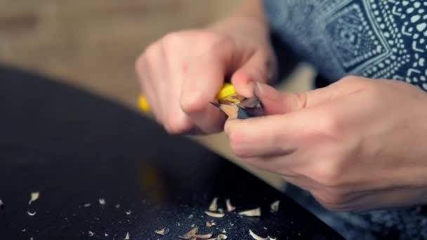 Närbild av en hand. man vässar en penna med kniv. — Stockvideo