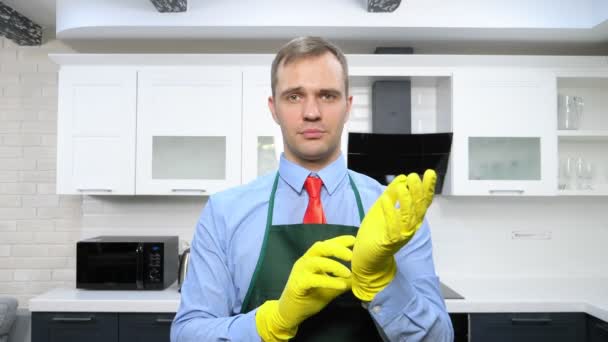 Handsome man in tie and apron wearing rubber gloves — Stock Video